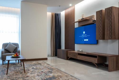 a living room with a tv and a chair at Vender Hotel in Taif