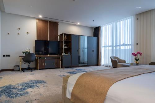 a bedroom with a bed and a flat screen tv at Vender Hotel in Taif
