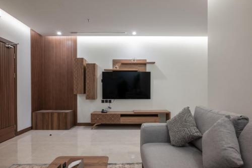 a living room with a couch and a flat screen tv at Vender Hotel in Taif