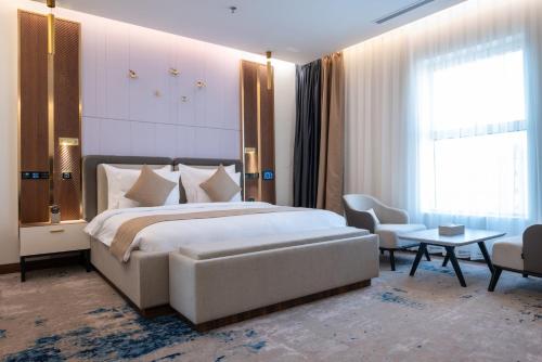 a bedroom with a large bed and a table and chairs at Vender Hotel in Taif