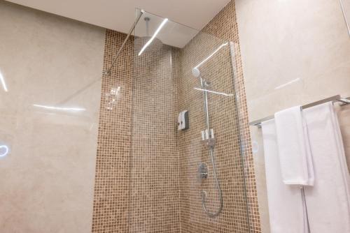 a bathroom with a shower with a glass door at Vender Hotel in Taif