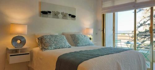 - une chambre avec un lit et un balcon dans l'établissement Cannes - Sea View- Swimming Pool - Parking - Beach, à Cannes