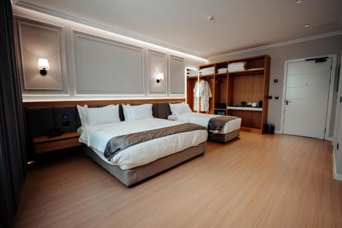 a large bedroom with two beds and a closet at Holiday Hotel in Tirana