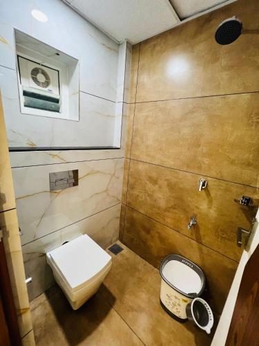 a small bathroom with a toilet and a mirror at Shanthi Tourist Home in Pathanāmthitta