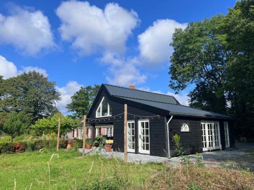 a black house with a black roof at Het Zomerhuis in Zuidbakkum