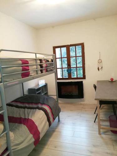 Cette chambre comprend des lits superposés, une table et une fenêtre. dans l'établissement La Bastide, à Sanary-sur-Mer