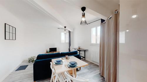 un salon avec un canapé bleu et une table dans l'établissement FLEGIER - St Charles Vieux Port, à Marseille