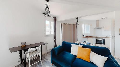 un salon avec un canapé bleu et une table dans l'établissement FLEGIER - St Charles Vieux Port, à Marseille