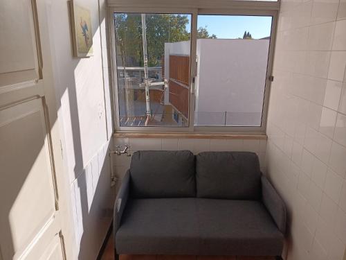 a couch in a small room with a window at Amoreiras Lisbon Apartments in Lisbon
