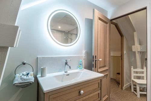 une salle de bain avec un lavabo et un miroir dans l'établissement La Grive - 400m Plage - Confort, à Étretat