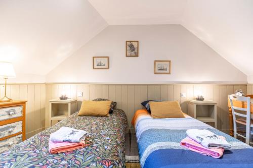 une chambre avec deux lits avec des serviettes dessus dans l'établissement La Grive - 400m Plage - Confort, à Étretat
