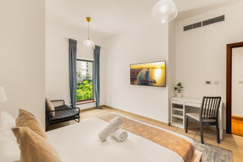 a bedroom with a bed and a desk and chairs at Beautiful 2BR & 4BR Apartments on JBR Beach, Walking Distance to Bluewaters Island - By Sunkissed Holiday Homes in Dubai