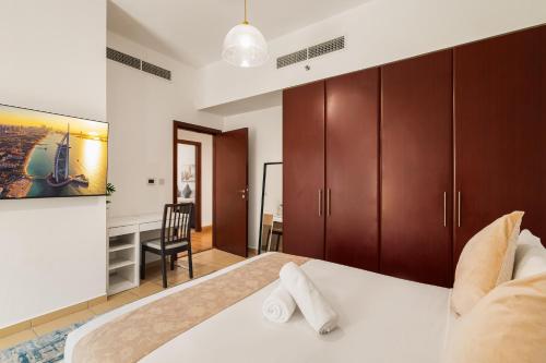 a bedroom with a large bed and a desk at Beautiful 2BR & 4BR Apartments on JBR Beach, Walking Distance to Bluewaters Island - By Sunkissed Holiday Homes in Dubai