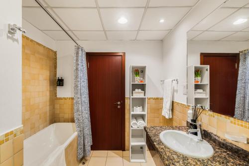a bathroom with a tub and a sink and a bath tub at Beautiful 2BR & 4BR Apartments on JBR Beach, Walking Distance to Bluewaters Island - By Sunkissed Holiday Homes in Dubai