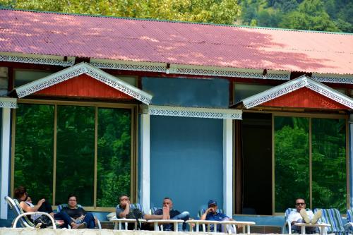 a group of people sitting at tables on a building at Keran Retreat in Upper Neelun