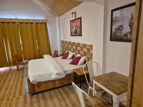 Un dormitorio con una cama y una mesa con sillas. en Rustic Retreat, en Manali