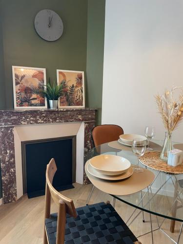 une salle à manger avec une table et une cheminée dans l'établissement My Cosy Green, Appartement Stylé et proche des commodités, à Nevers
