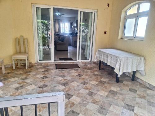 a living room with a table on a tiled floor at Grenadier A in Flic-en-Flac