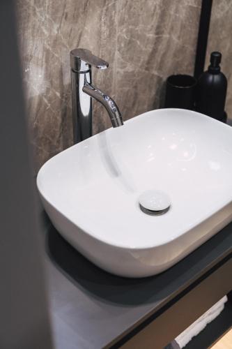 a white sink with a faucet on a counter at Home Avenue in Alexandroupoli
