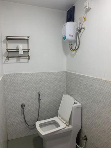 a bathroom with a white toilet and a phone on the wall at Sydney X Huts in Arambol