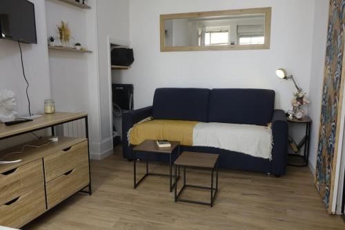 un salon avec un canapé bleu et une table dans l'établissement Studio Gare Dijon centre, à Dijon