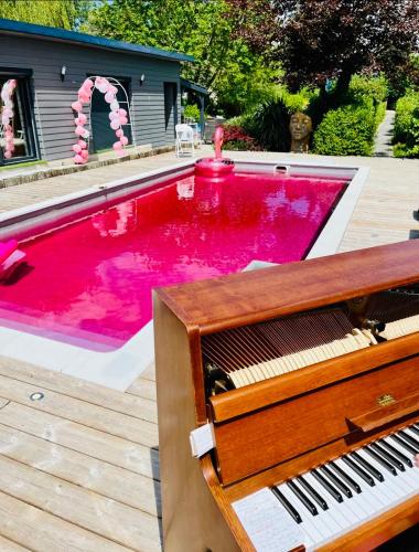a pool with red water and a piano at le chant de la rivière in Abbeville