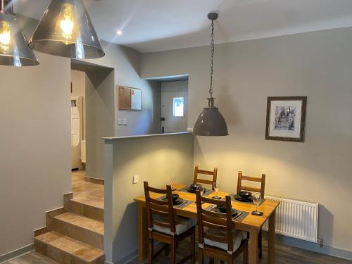 a dining room with a wooden table and chairs at Grange Cottage in Ballynoe