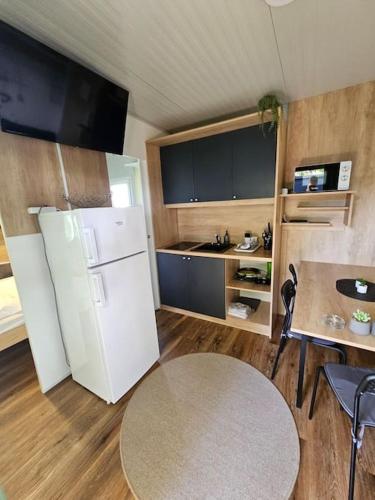 メトリカにあるL&A Mobile Houseの白い冷蔵庫とテーブルのあるキッチン