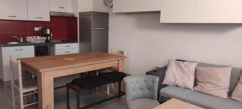 une petite cuisine avec une table et un canapé dans l'établissement Pergola, à Saint-Cyprien