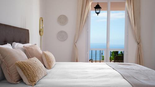 a bedroom with a bed with a view of the ocean at NostraCasa by LovelyStay in Caniço