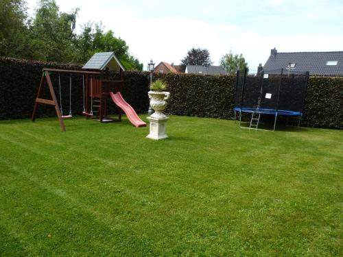 a yard with a playground with a table and swings at Gite les bons amis in Plombières