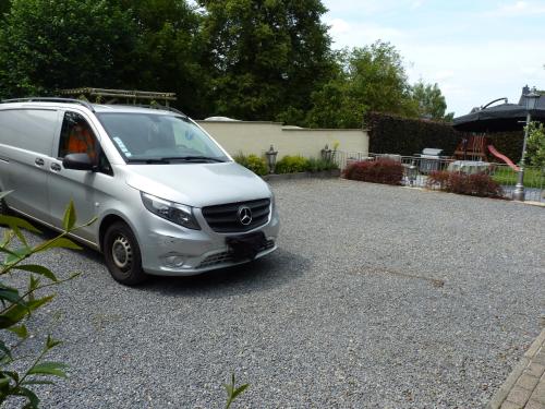 a silver van parked in a gravel parking lot at Gite les bons amis in Plombières