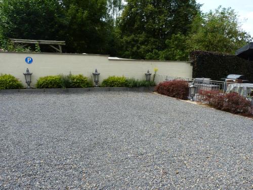 a gravel driveway in front of a white building at Gite les bons amis in Plombières