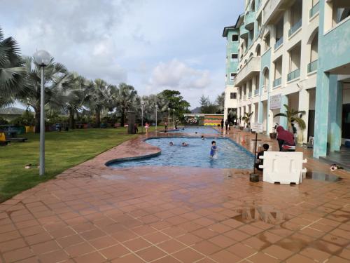 a pool in a park with people swimming in it at Glossy Marina Homestays in Lumut