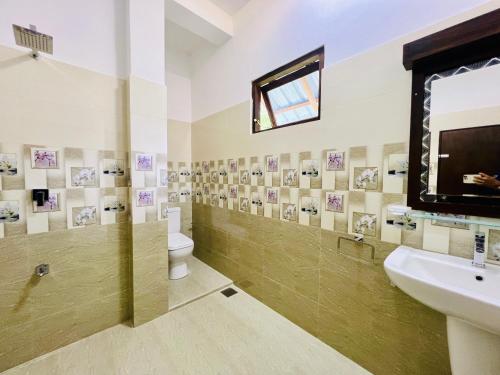 a bathroom with a toilet and a sink and a mirror at Adithya Seaview Villa - Tangalle in Tangalle