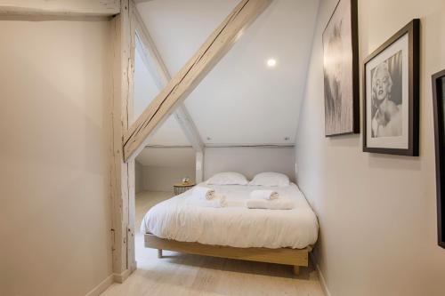 une chambre avec un lit avec deux serviettes dessus dans l'établissement Centre Ville Deauville, à Deauville