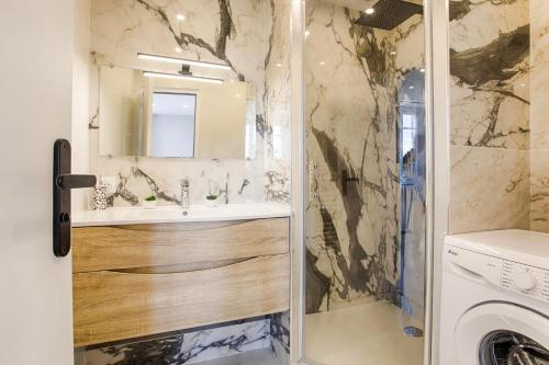 une salle de bain avec un lavabo et une machine à laver dans l'établissement Centre Ville Deauville, à Deauville