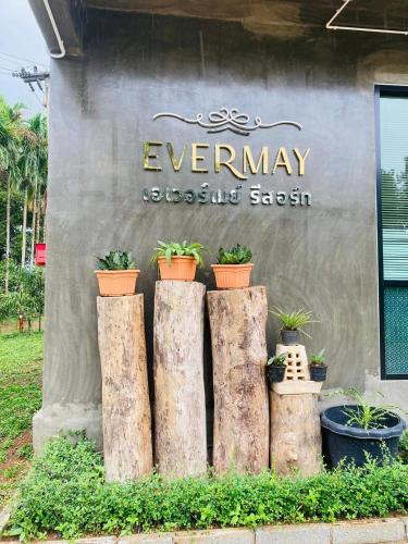 a sign with four tree stumps in front of a building at เอเวอร์เมย์ รีสอร์ท Evermay Resort in Ban Plai Khlong