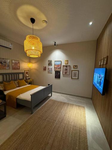 a bedroom with a bed and a flat screen tv at Small details2 Self-check-in in Riyadh