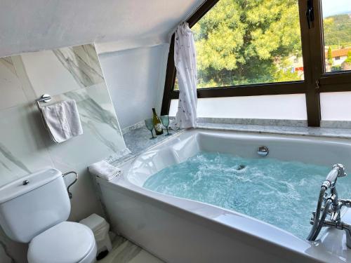 a bathroom with a bath tub with a window at Hospedaje Javier - ALOJATEISLA in Isla