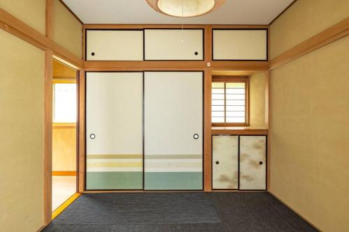 an empty room with glass doors in a building at Nikko Toyama Forest House in Nikko