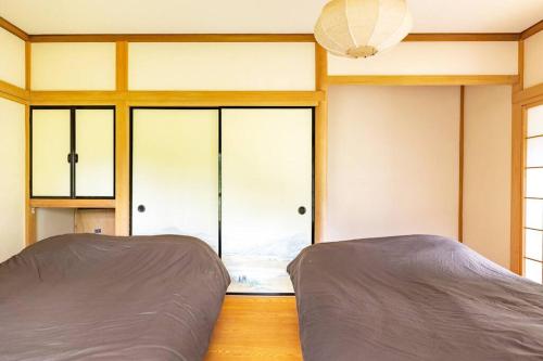 a bedroom with two beds and a window at Nikko Toyama Forest House in Nikko