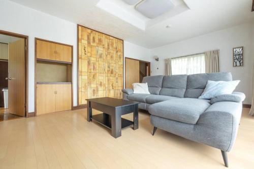 a living room with a couch and a table at Nikko Toyama Forest House in Nikko