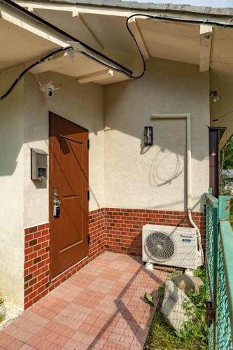 a front of a house with a door and a fan at Nikko Toyama Forest House in Nikko