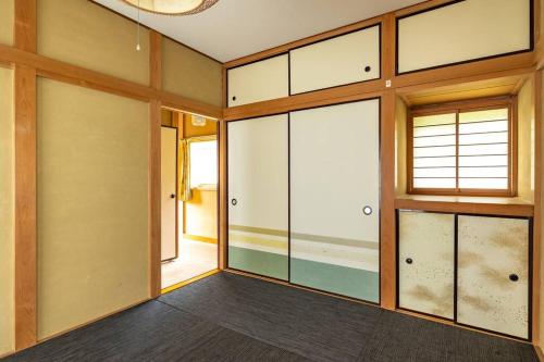 an empty room with glass doors and a window at Nikko Toyama Forest House in Nikko