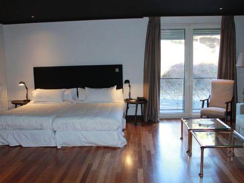 a bedroom with a large bed and a living room at Hotel Hita "Nature Experience" for all in Navacerrada
