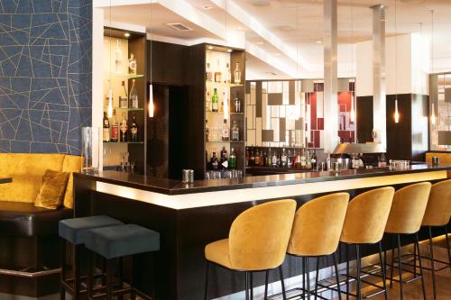 a bar with a row of stools in a restaurant at See Park Janssen in Geldern
