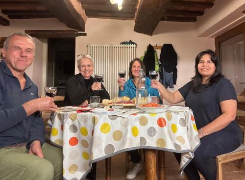 a group of people sitting around a table with wine glasses at Monte Cuccolo House B&B in Fontanelice