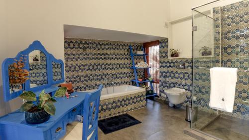 a blue bathroom with a tub and a toilet at Villa Shangri-La by tisyastays in Nerul