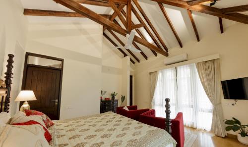 a bedroom with a bed and a couch and a television at Villa Shangri-La by tisyastays in Nerul